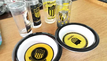 5 vasos y 2 platos todos con logo de peñarol