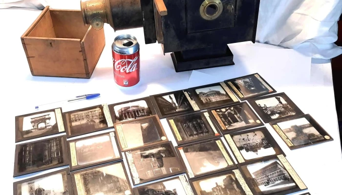 Antiguo proyector de chapa y bronce con muchas diapositivas en vidrio
