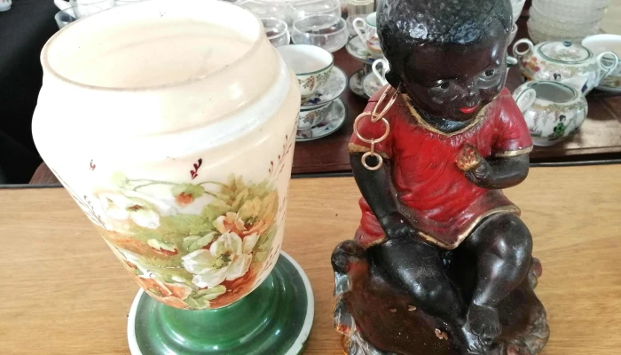 muñeca negra con averia y florero